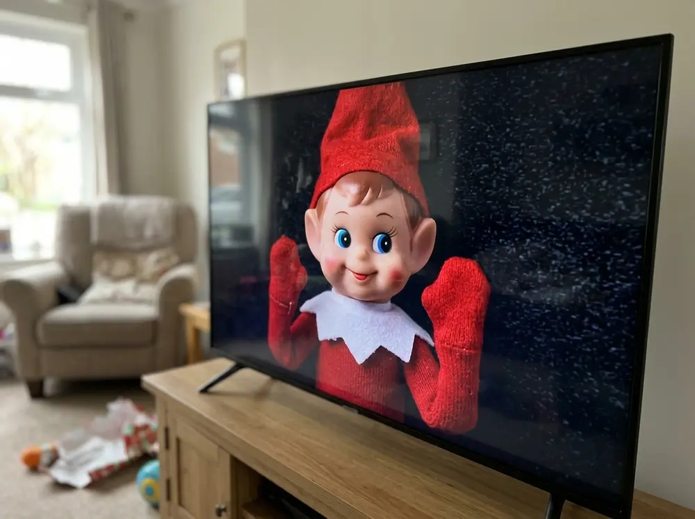 Take a photo of the toy elf doll pressed against glass, set it as the TV background overnight — the toy elf doll got 'stuck inside the television.'