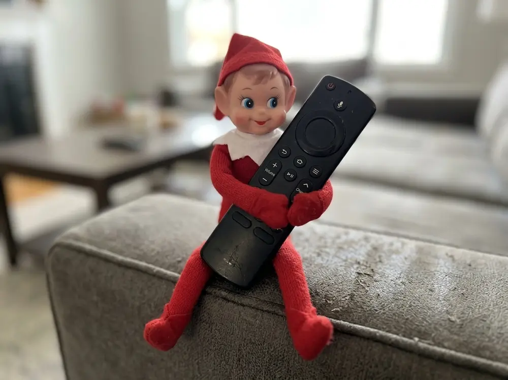 Sit the toy elf doll on the couch clutching the TV remote like it owns movie night