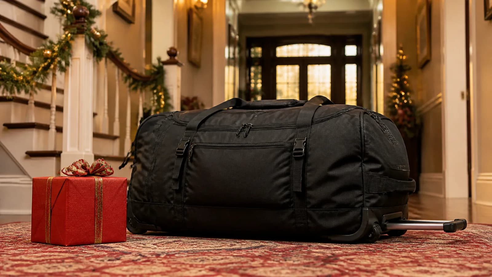 Representative large black rolling duffel beside a red Christmas box