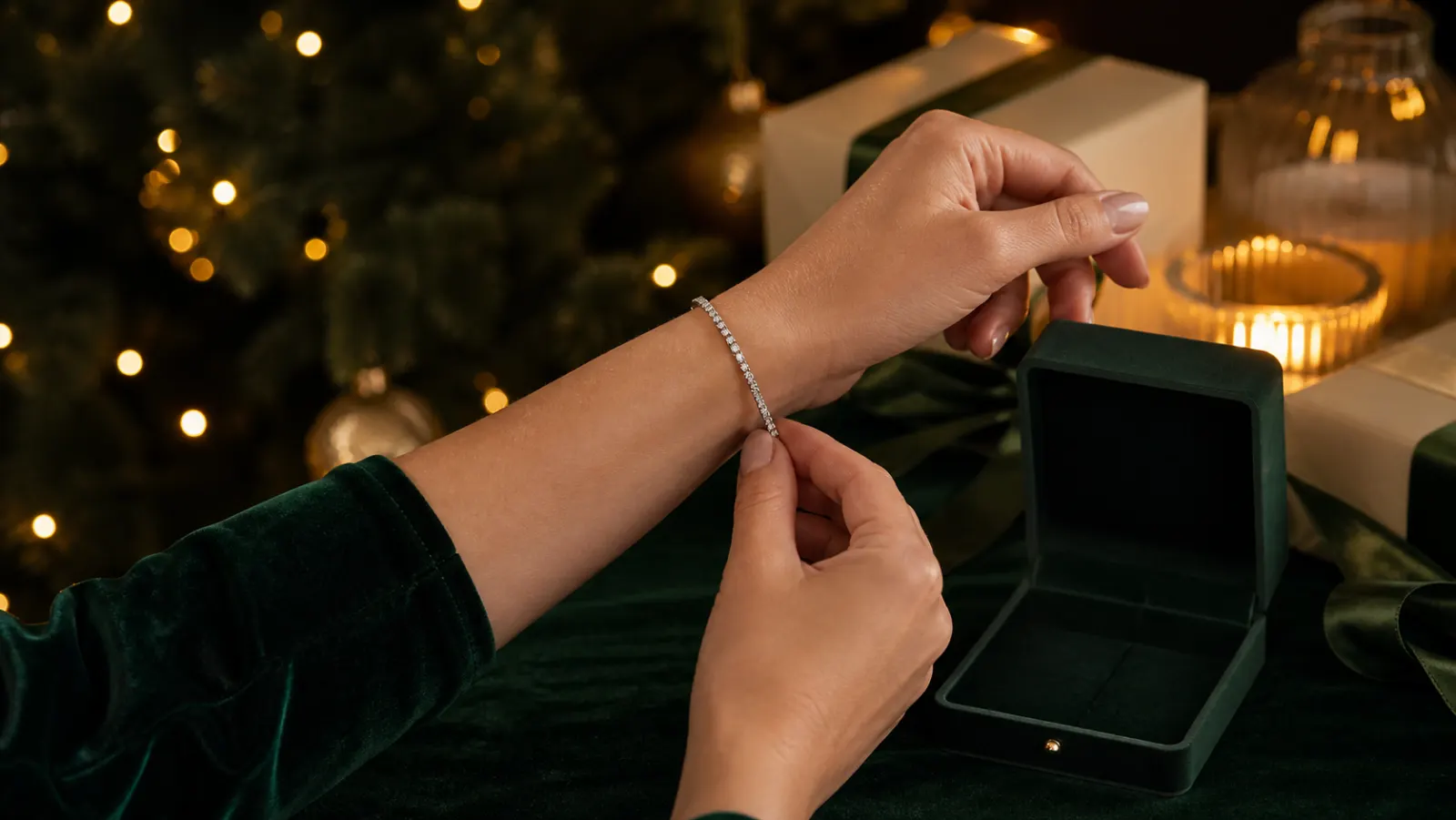 Representative white-stone silver-tone tennis bracelet being fastened beside a Christmas jewellery box